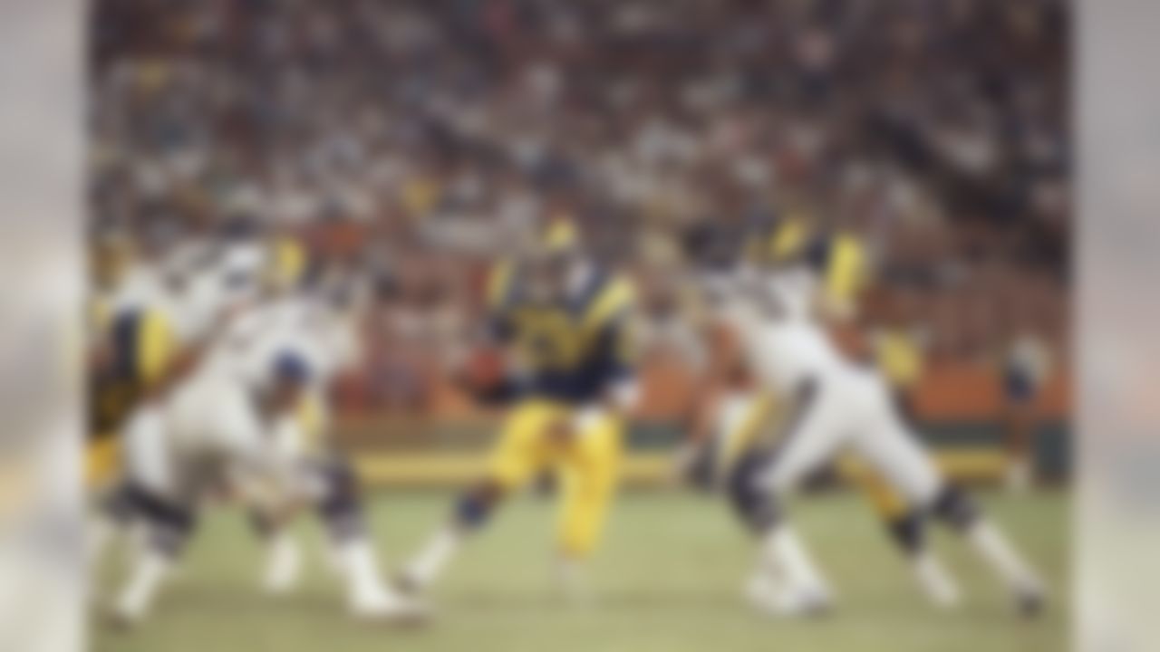 Los Angeles Ram running back Eric Dickerson, center, cuts through a wide hole in the San Francisco defense, including Thomas Benson (57, left) and Leslie O?Neal (91, right) for a 15-yard gain in the second quarter of NFL preseason game at Anaheim Stadium, Saturday, August 23, 1986, Anaheim, Calif. Earlier in the quarter Dickerson had run 74 yards for a touchdown. (AP Photo/Lennox McLendon)