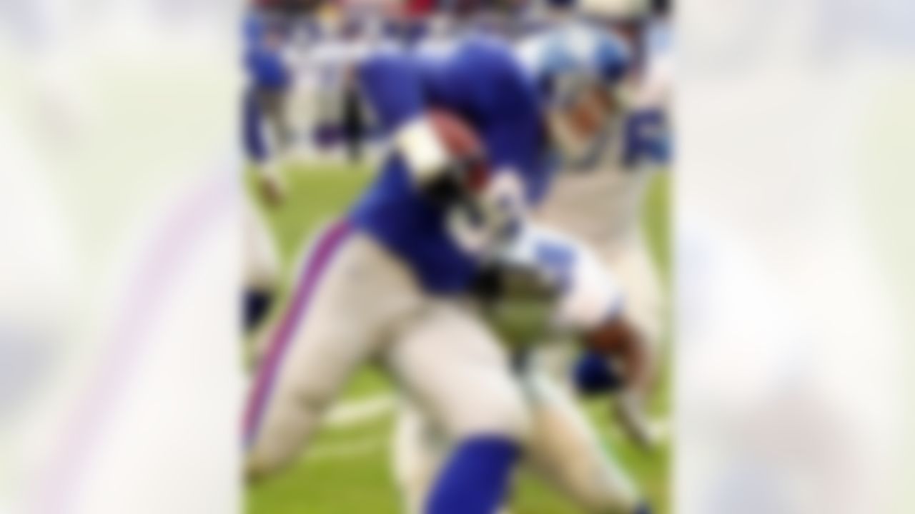 New York Giants defensive end Michael Strahan picks up a fumble and runs by Seattle Seahawks fullback Mack Strong for a 13-yard touchdown at Giants Stadium in East Rutherford, N.J., Dec. 23, 2001. (AP Photo/Bill Kostroun)