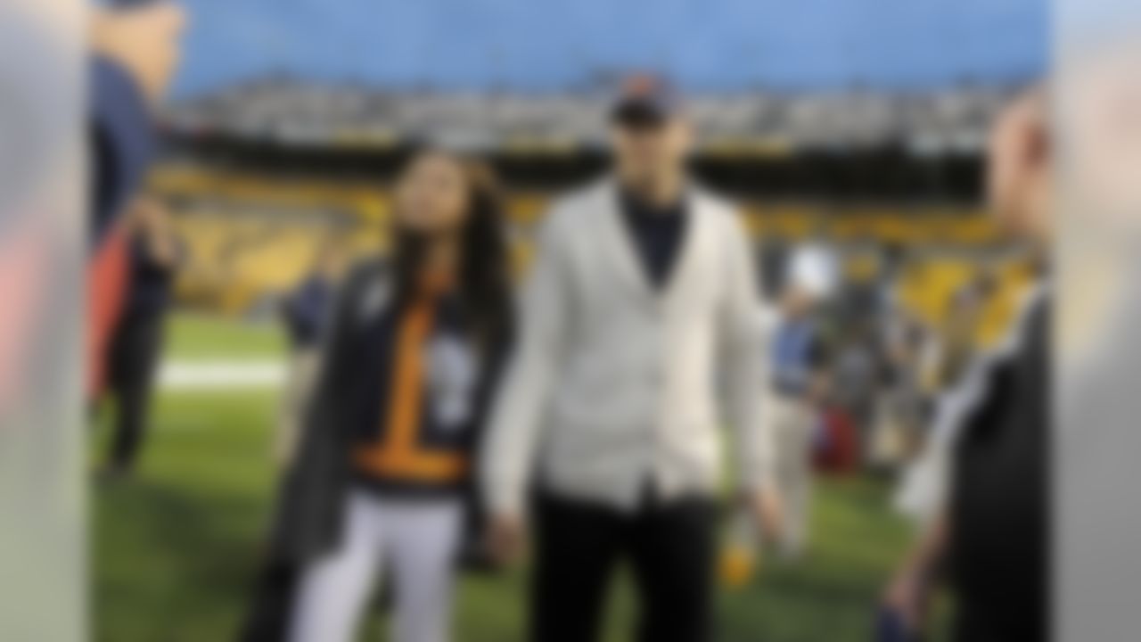 Ashton Kutcher, center right, and Mila Kunis walk along the sideline before the NFL football game between the Pittsburgh Steelers and the Chicago Bears at Heinz Field on Sunday, Sept. 22, 2013, in Pittsburgh. (AP Photo/Keith Srakocic)