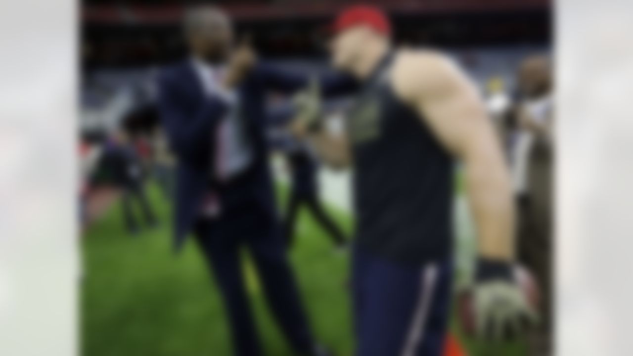 Former NBA player Dikembe Mutombo, left, does his signature finger wave with Houston Texans defensive end J.J. Watt before an NFL football game, against the Baltimore Ravens Sunday, Dec. 21, 2014, in Houston. (AP Photo/David J. Phillip)