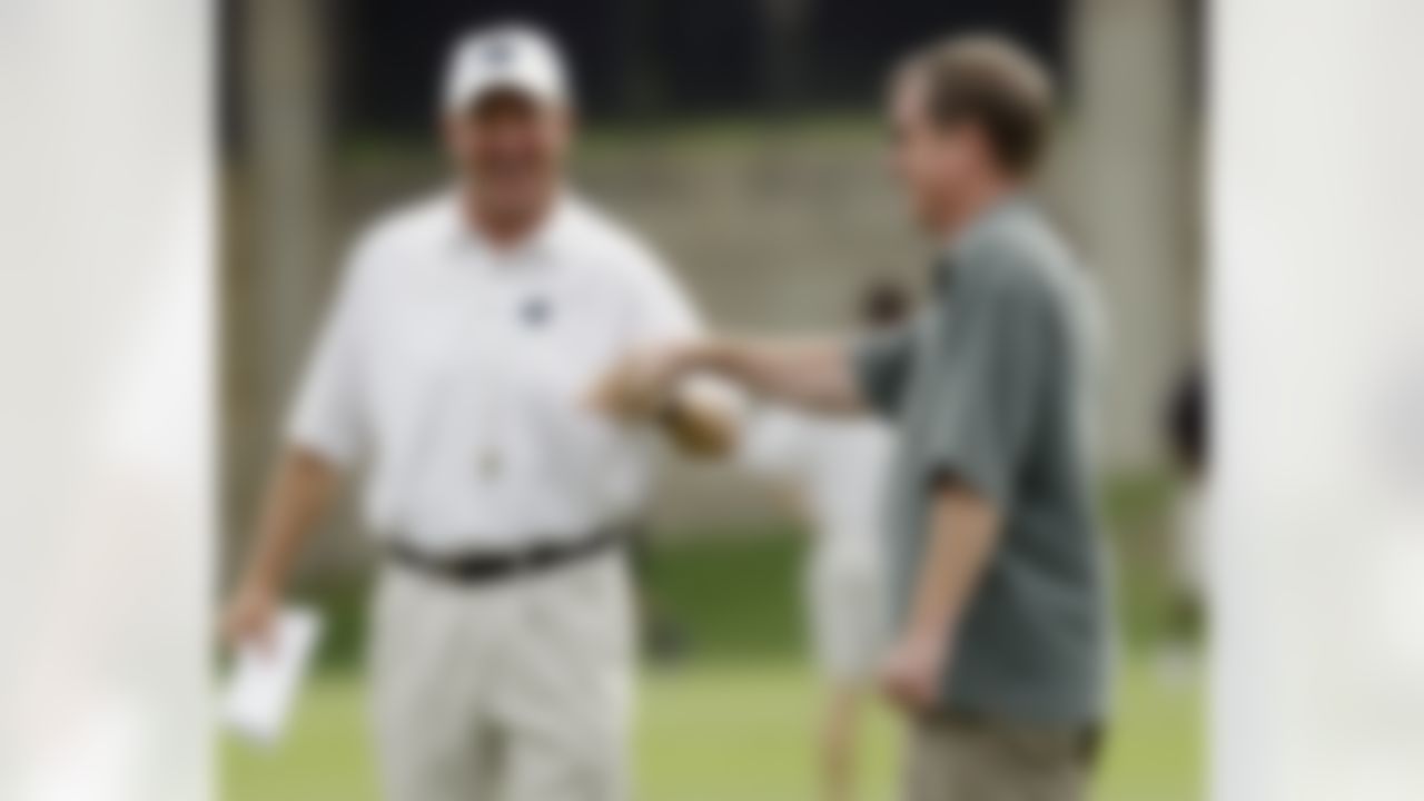 Carolina Panthers head coach John Fox, left, gets a fist bump from general manager Marty Hurney, right, during a summer training practice session for the NFL football team in Charlotte, N.C., Wednesday, June 16, 2010. (AP Photo/Chuck Burton)