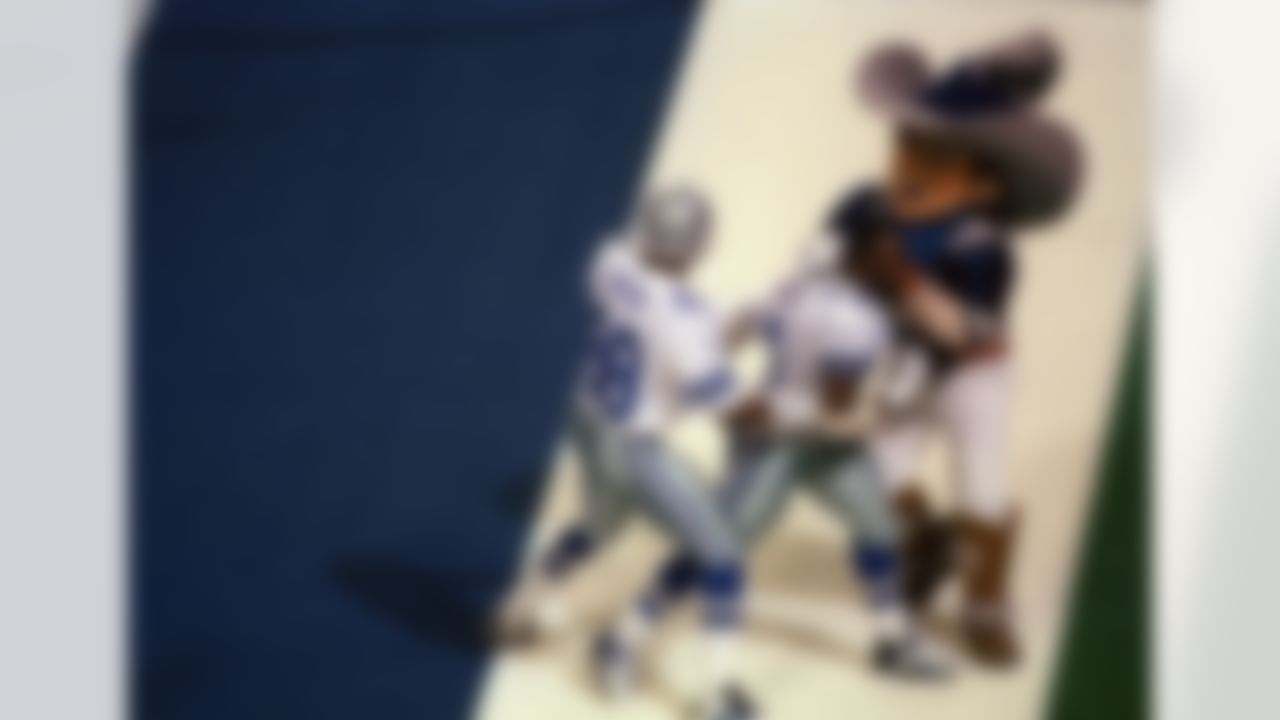 Dallas Cowboys Emmitt Smith (22), center, celebrates his third quarter touchdown with teammate Michael Irvin (88) and an enthusiastic cowboy mascot during Super Bowl XXVIII at the Georgia Dome on Jan. 30, 1994. The Cowboys went on to beat the Buffalo Bills 30-13 for their second straight Super Bowl championship. (AP Photo/Susan Walsh)