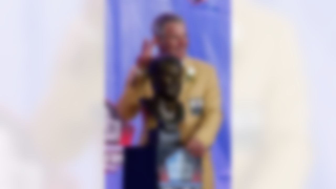 Former NFL player Brett Favre poses with his bust during an induction ceremony at the Pro Football Hall of Fame Saturday, Aug.6, 2016, in Canton, Ohio. (AP Photo/Ron Schwane)