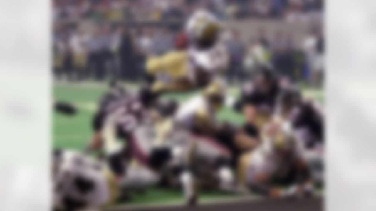 New Orleans Saints running back Ricky Williams (34) dives over Atlanta Falcons linebacker Mark Simoneau (53) as he scores a fourth-quarter touchdown Sunday, Oct. 22, 2000, in Atlanta. (AP Photo/John Bazemore)