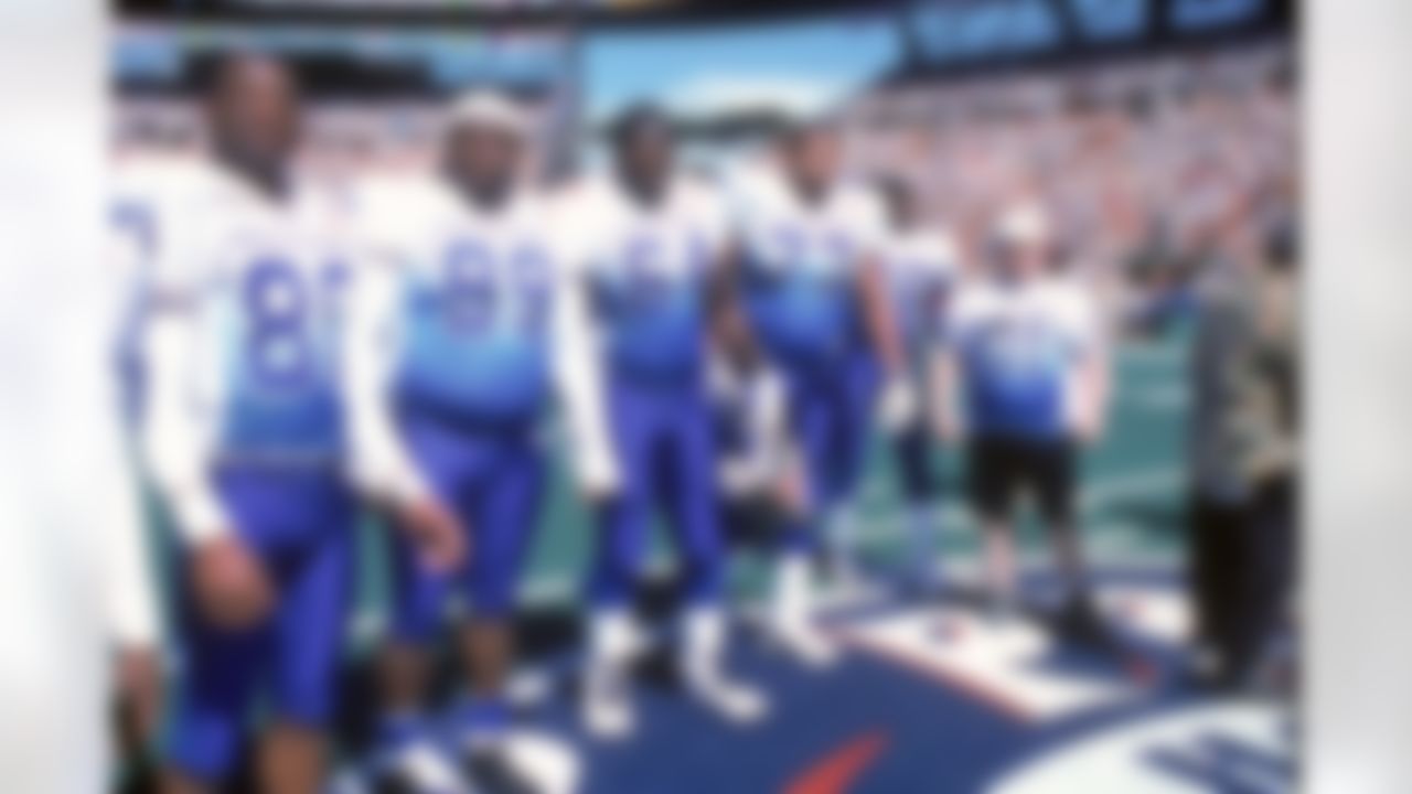 Vikings WR Cris Carter, Buccaneers DT Warren Sapp and OG Randall McDaniel and Saints OG Willie Roaf of the NFC pose with a fan before the coinflip before playing against the AFC in the 2001 NFL Pro Bowl at Aloha Stadium in Honolulu, Hawaii. The AFC defeated the NFC 38-17. (National Football League)