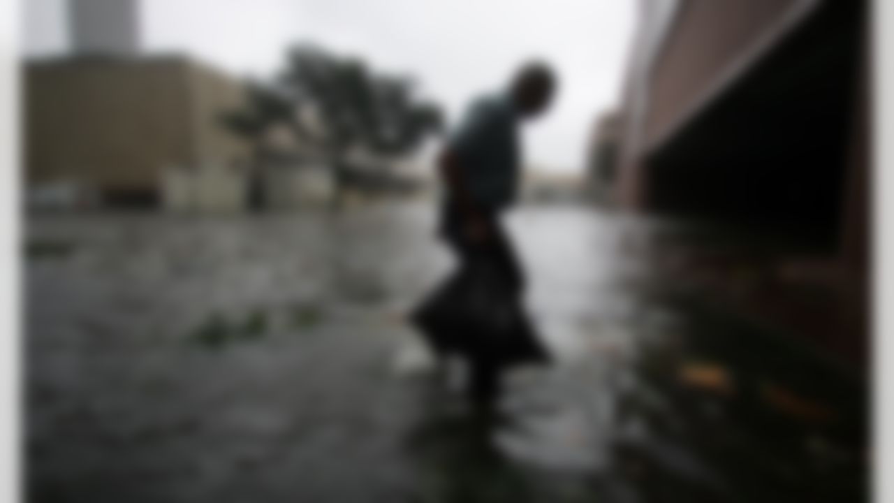 Arnold James carries a small bag of belongings through floodwaters as he tries to make his way on foot to the Superdome in New Orleans on Monday, Aug. 29, 2005. The roof on James' home had been blown off, forcing him to seek shelter elsewhere. (AP Photo/Dave Martin)