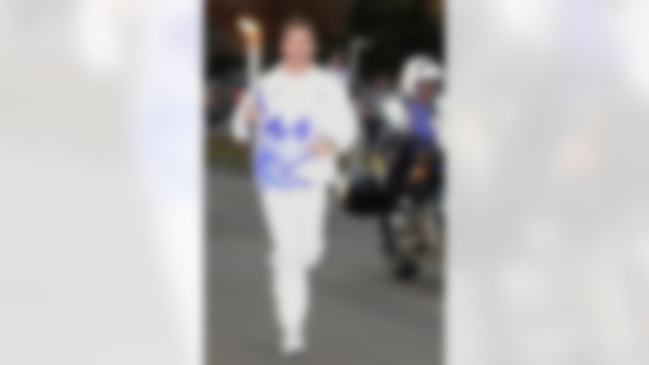 Former Dallas Cowboys quarterback Troy Aikman caries the Olympic torch in Dallas, Wednesday evening, Dec 12, 2001. Aikman ran the torch for two blocks. (AP Photo/LM Otero)