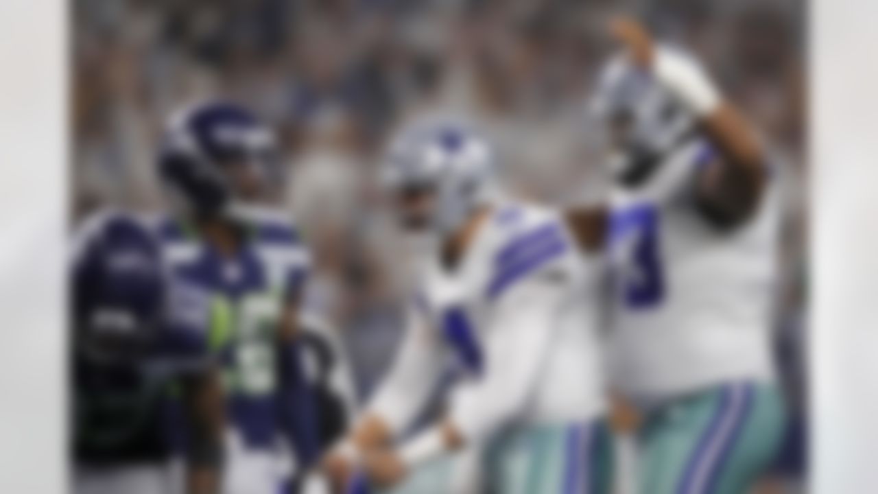Dallas Cowboys quarterback Dak Prescott (4) celebrates on the field with center Joe Looney (73) after a touchdown try against the Seattle Seahawks. Prescott led the Cowboys to a 24-22 win against the Seahawks with an 11-yard passing touchdown to rookie Cowboys wide receiver Michael Gallup and a game-winning touchdown run with less than three minutes remaining in the game.