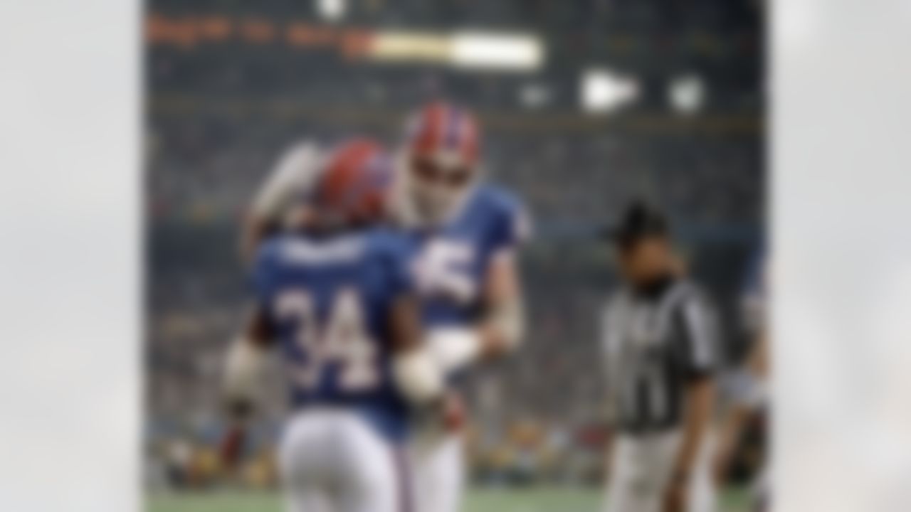 Buffalo Bills guard John Davis (65) congratulates running back Thurman Thomas (34) after Thomas scored a four-yard touchdown during Super Bowl XXVIII, a 30-13 loss to the Dallas Cowboys on January 30, 1994, at the Georgia Dome in Atlanta, Georgia. (National Football League)