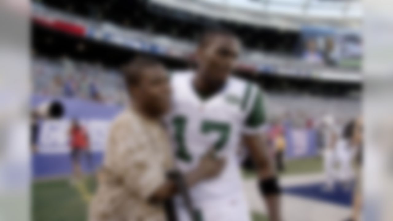 Actor Tracy Morgan, left, greets New York Jets' Plaxico Burress before an NFL preseason football game between the New York Jets and the New York Giants, Monday, Aug. 29, 2011, in East Rutherford, N.J. (AP Photo/Julio Cortez)