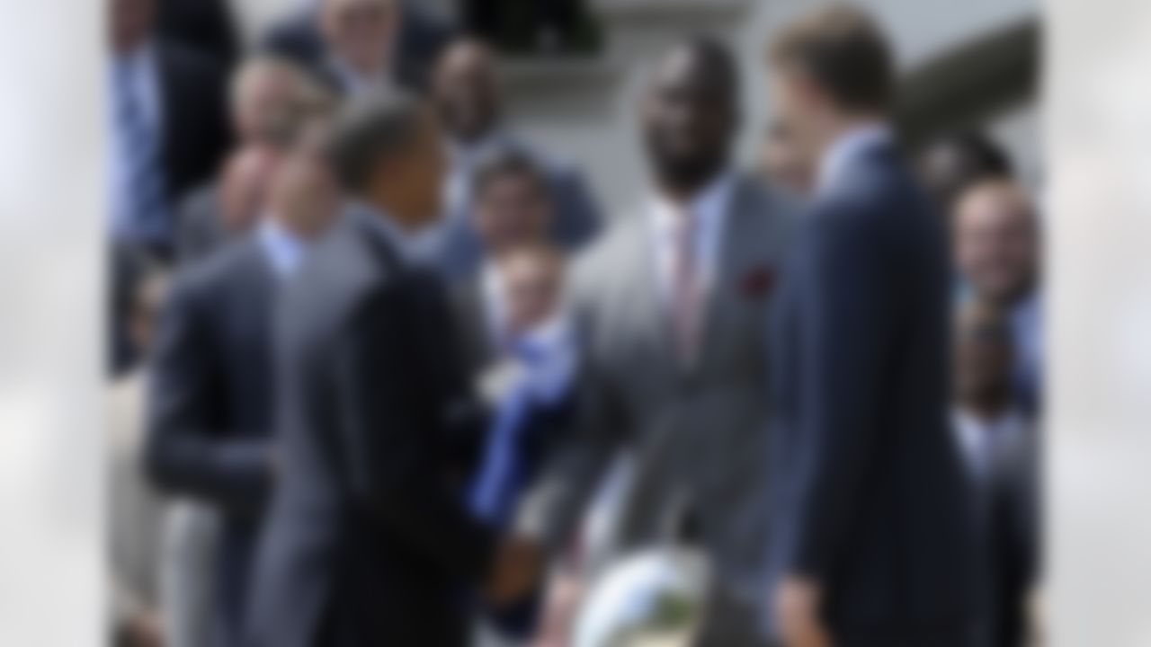 President Barack Obama shakes hands with New York football Giants player Justin Tuck, center, as teammates Zak DeOssie, left, and Eli Manning, right, watch, during a ceremony on the South Lawn of the White House in Washington, Friday, June 8, 2012, where the president honored the Super Bowl XLVI Champions. (AP Photo/Susan Walsh)