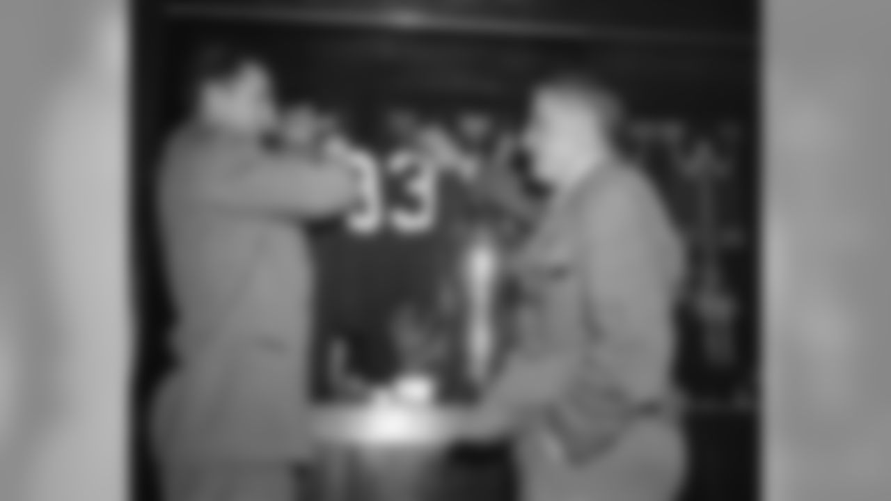 Sammy Baugh, one of the greatest passers in football history, hangs up his famous No. 33 jersey in the Washington Redskins trophy case in Washington on Dec. 8, 1952 as he announces he's through as a grid player after next Sunday's game. George Marshall, club owner is at right. (AP Photo/WCA)