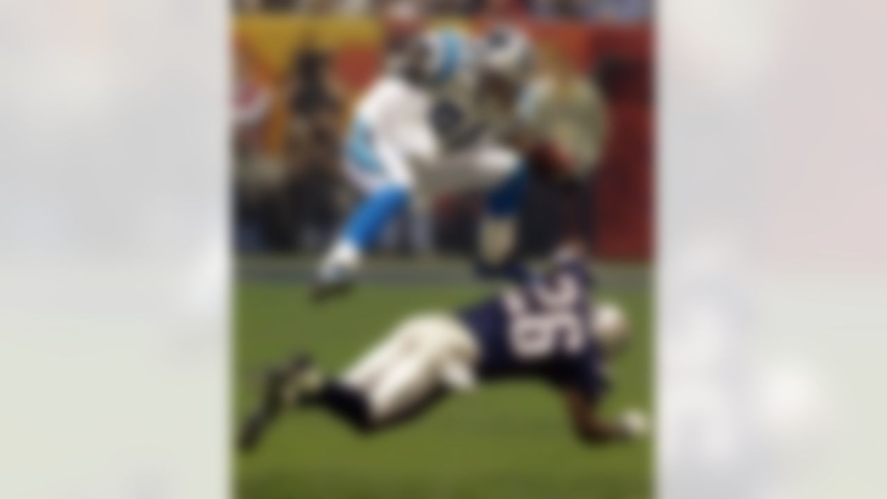 Carolina Panthers Jermaine Wiggens (84) leaps over New England Patriots Eugene Wilson (26) to avoid being tackled during the third quarter of Super Bowl XXXVIII at the Reliant Stadium in Houston, TX Sunday Feb. 1, 2004. (AP Photo/Eric Gay)