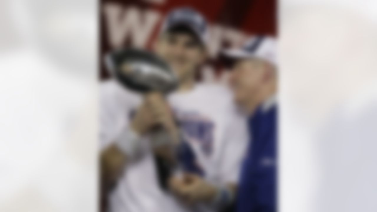 New York Giants quarterback Eli Manning, left, and his coach Tom Coughlin look at the Vince Lombardi Trophy as they celebrate after the Giants beat the New England Patriots 17-14 in the Super Bowl XLII football game in Glendale, Ariz. (AP Photo/Stephan Savoia)