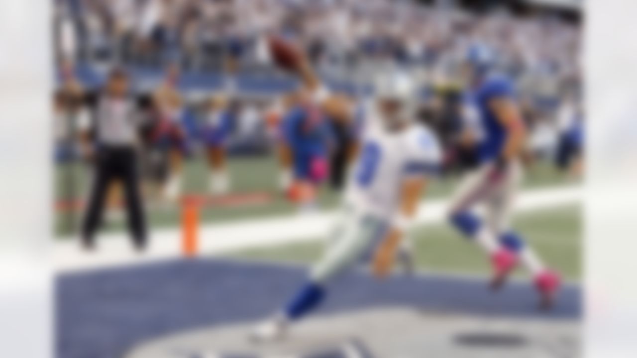 Dallas Cowboys quarterback Tony Romo (9) gets past New York Giants middle linebacker Chase Blackburn (93) to score a touchdown during the second half of an NFL football game Sunday, Oct. 28, 2012 in Arlington, Texas. (AP Photo/Sharon Ellman)
