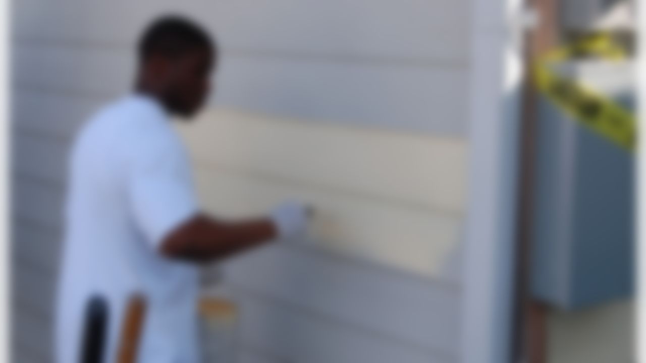 Reggie Bush of the New Orleans Saints puts a fresh coat of paint on a home ravaged by Hurricane Katrina in New Orleans, Louisiana on June 10, 2008.