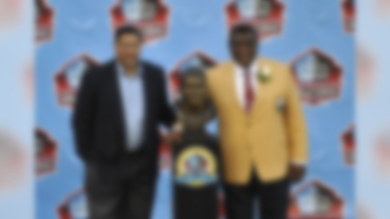 Inductee Dave Robinson, right, poses with his presenter, his son David Robinson, and a bust of himself during the induction ceremony at the Pro Football Hall of Fame Saturday, Aug. 3, 2013, in Canton, Ohio. (AP Photo/David Richard)