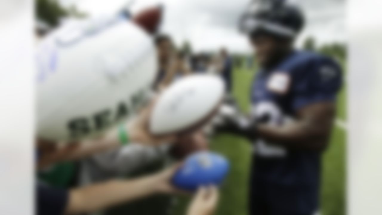 Seattle Seahawks running back Robert Turbin signs autographs, Saturday, July 28, 2012, following the first day of Seattle Seahawks NFL football training camp. (AP Photo/Ted S. Warren)