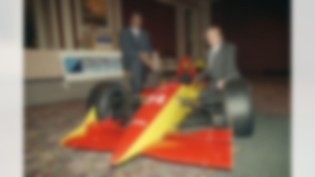 Former Chicago Bears runningback Walter Payton, left, and Dale Coyne pose with their Indy style race car on Wednesday, Dec. 7, 1994 in Chicago. Payton has joined into a partnership with Coyne to race on the IndvCar circuit. (John Swart/Associated Press)