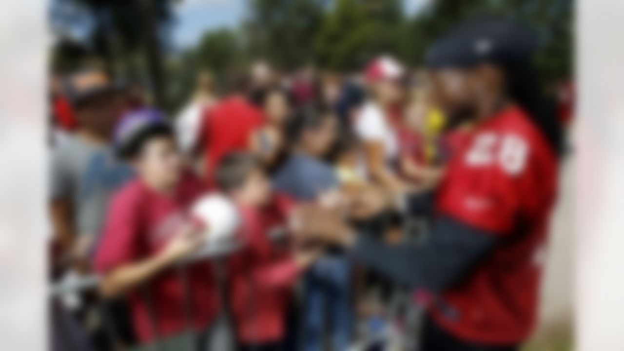 Arizona Cardinals' Greg Toler (28) signs autographs for fans after NFL training camp football practice at Northern Arizona University, Thursday, July 26, 2012, in Flagstaff, Ariz. (AP Photo/Ross D. Franklin)
