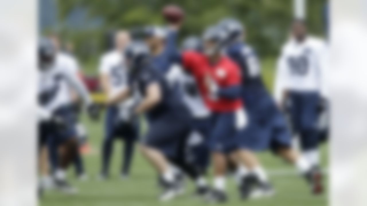Seattle Seahawks quarterback Russell Wilson passes as John Moffitt, center left, blocks, Saturday, July 28, 2012, on the first day of the NFL football team's training camp in Renton, Wash. (AP Photo/Ted S. Warren)