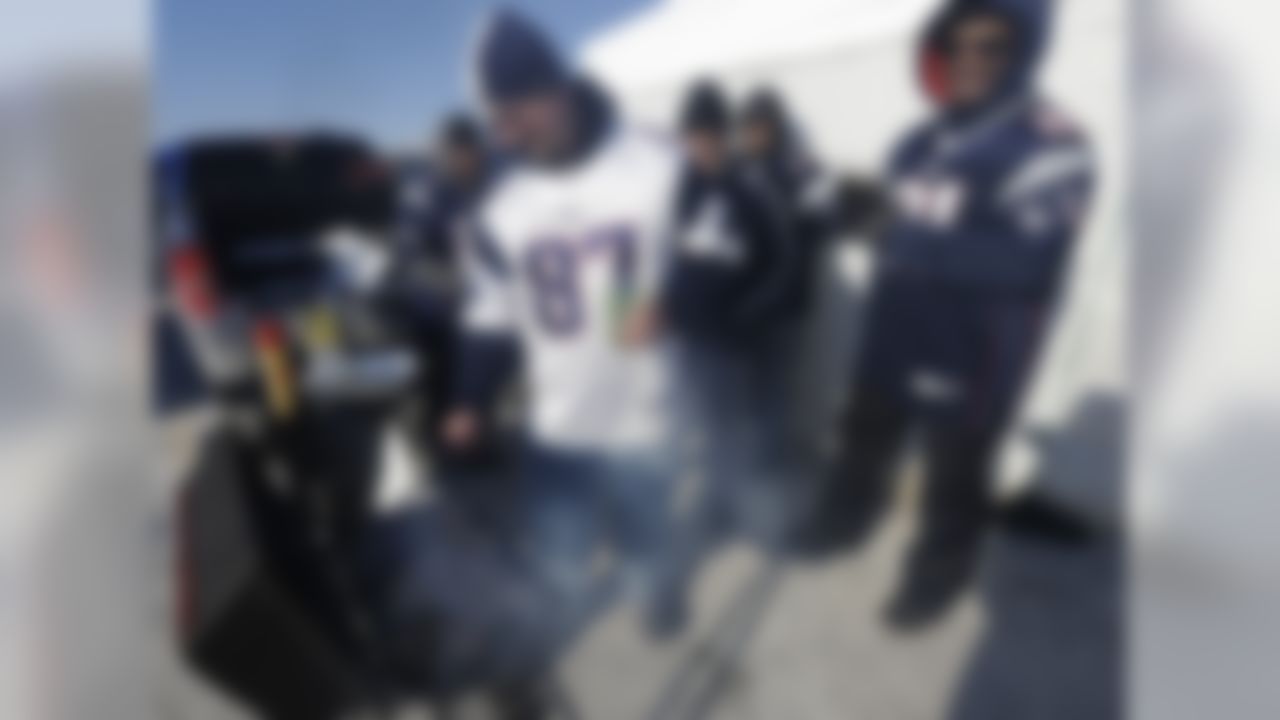New England Patriots fans John Cummings, left, mans the grill while tailgating with friends including Tivo Concepcion, right, both from Methuen, Mass., in the Gillette Stadium parking lot before an NFL divisional playoff football game between the Patriots and the Baltimore Ravens Saturday, Jan. 10, 2015, in Foxborough, Mass. (AP Photo/Steven Senne)