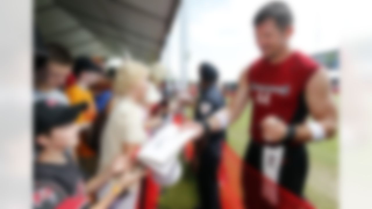 Tampa Bay Buccaneers' Dallas Clark, right, signs autographs for fans after a workout at NFL football training camp, Saturday, July 28, 2012, in Tampa, Fla. (AP Photo/Mike Carlson)