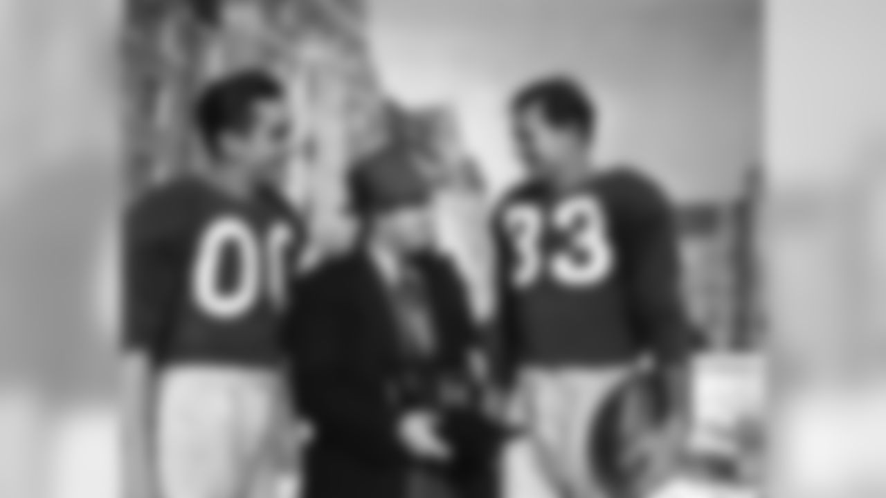 William Smith, center, AP-WX photographer, chats with two Washington Redskin stars, Steve Bagarus, left, and Sammy Baugh, right, as he makes pictures of their workouts in Washington on Dec. 14, 1945 prior to their pro championship game with the Cleveland Rams. (AP Photo/WX)