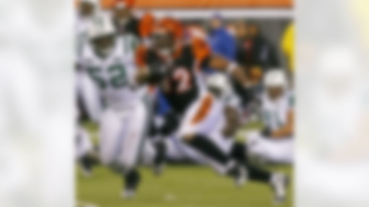 Cincinnati Bengals running back Cedric Benson (32) runs past New York Jets linebacker David Harris (52) in the second half of an NFL wild-card playoff football game, Saturday, Jan. 9, 2010, in Cincinnati. (AP Photo/David Kohl)
