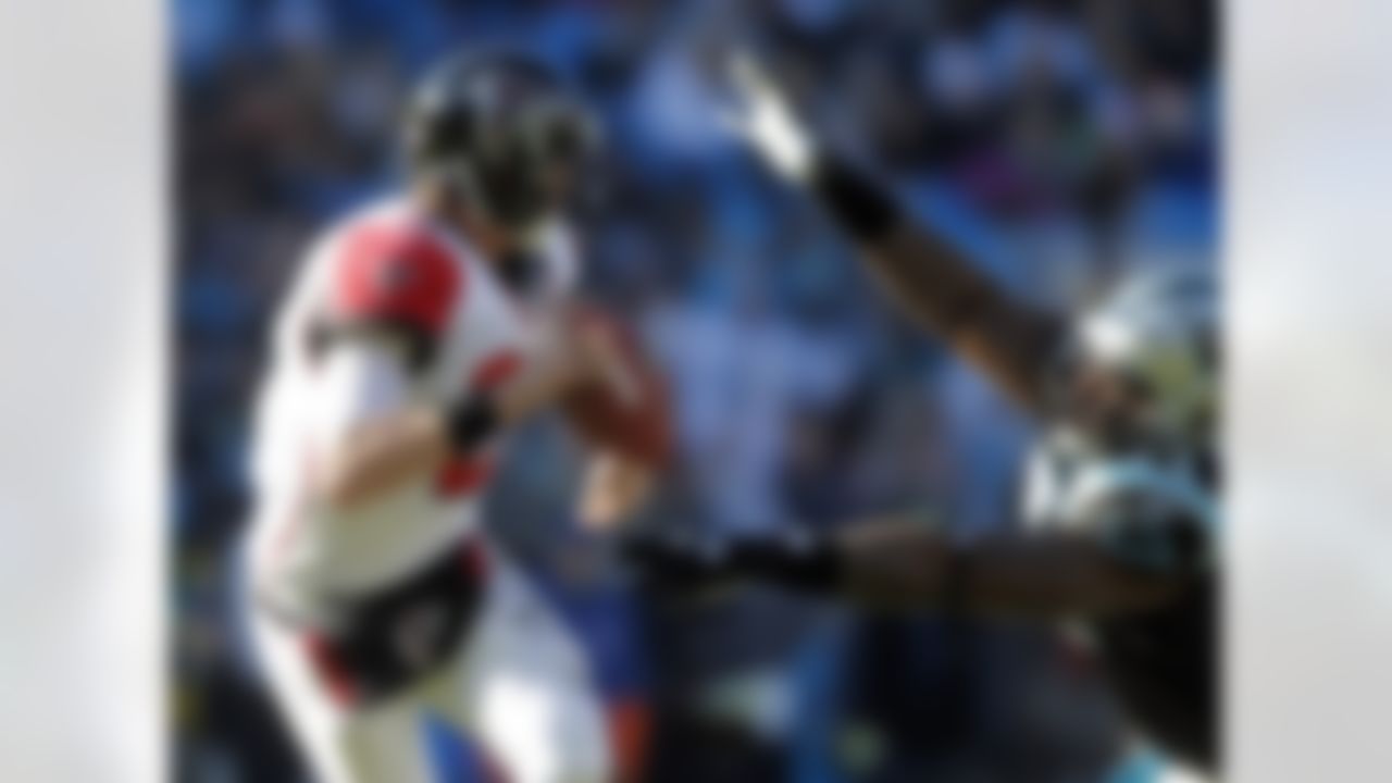 Atlanta Falcons' Matt Ryan, left, scrambles under pressure from Carolina Panthers' Jason Shirley, right, during the second quarter of an NFL football game in Charlotte, N.C., Sunday, Dec. 11, 2011. (AP Photo/Bob Leverone)