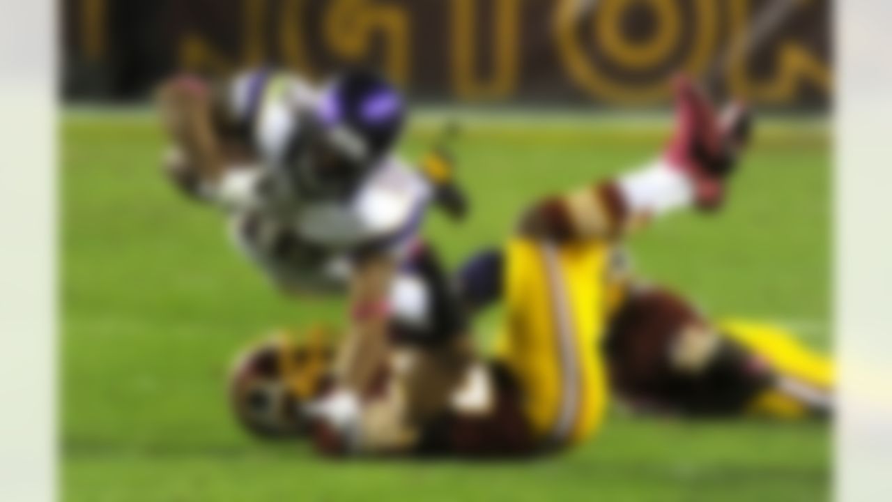 Vikings' Percy Harvin (12) stretches for extra yardage as he's being brought down by Redskins' Josh Wilson (26) during fourth quarter of their NFL football game Sunday, Oct. 14, 2012, in Landover, Md. Washington defeated Minnesota 38-26. (AP Photo/Richard Lipski)