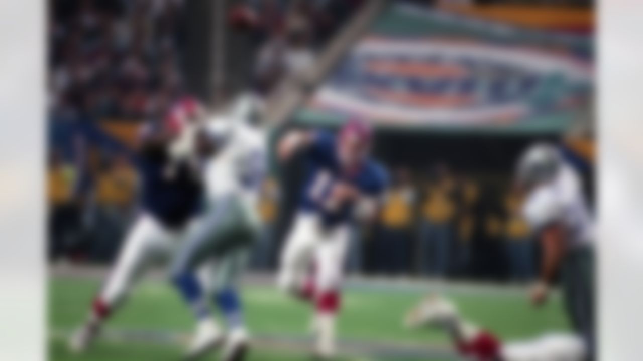 Buffalo Bills Hall of Fame quarterback Jim Kelly (12) throws a pass behind a block by tackle Howard Ballard (75) on Dallas Cowboys defensive end Tony Tolbert (92) during the Super Bowl XXVIII NFL game in Atlanta, Ga., on January 30, 1994. The Cowboys defeated the Bills 30-13. (AP Photo/Paul Spinelli)