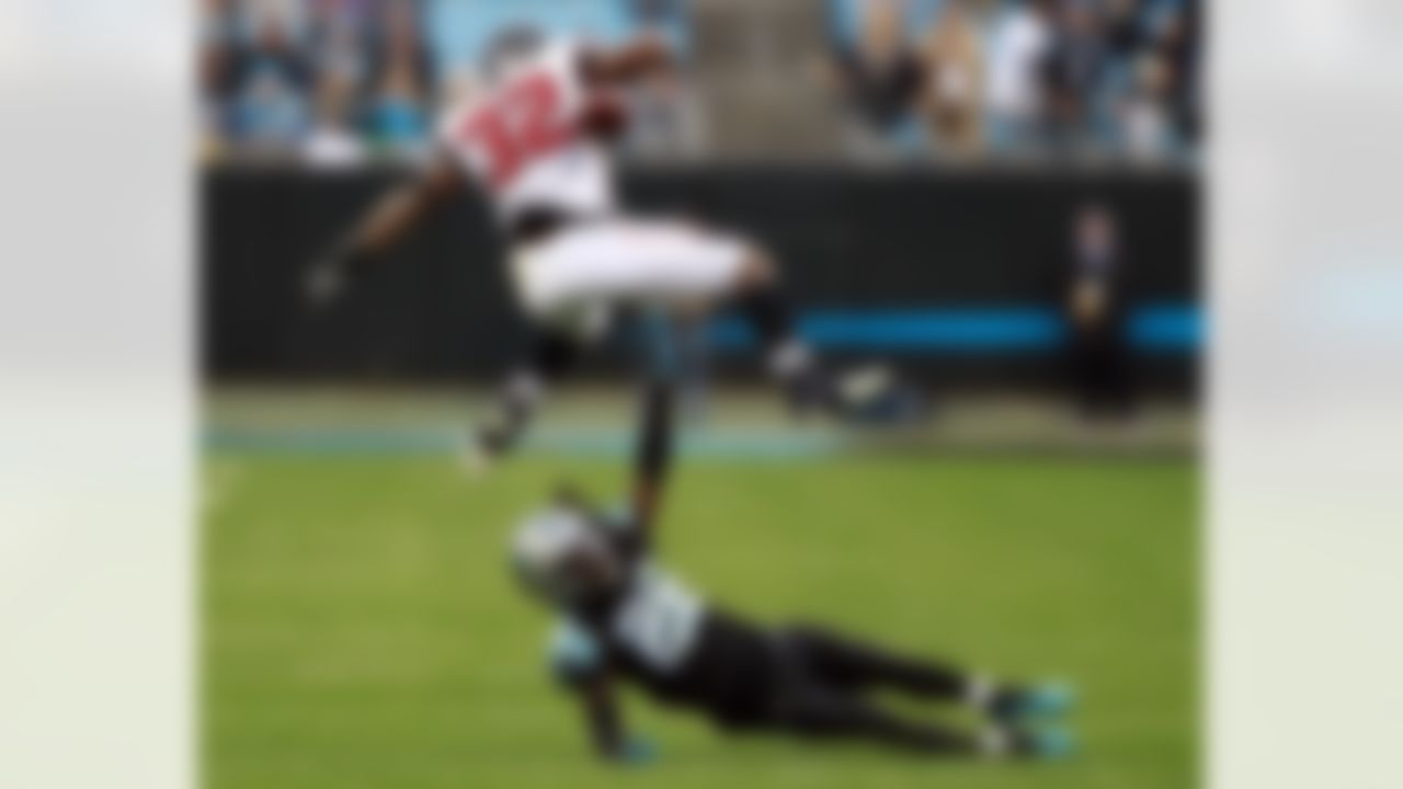 Atlanta Falcons' Brian Hill (32) fumbles the ball as he hurdles Carolina Panthers' Donte Jackson (26) during the second half of an NFL football game in Charlotte, N.C., Sunday, Dec. 23, 2018.