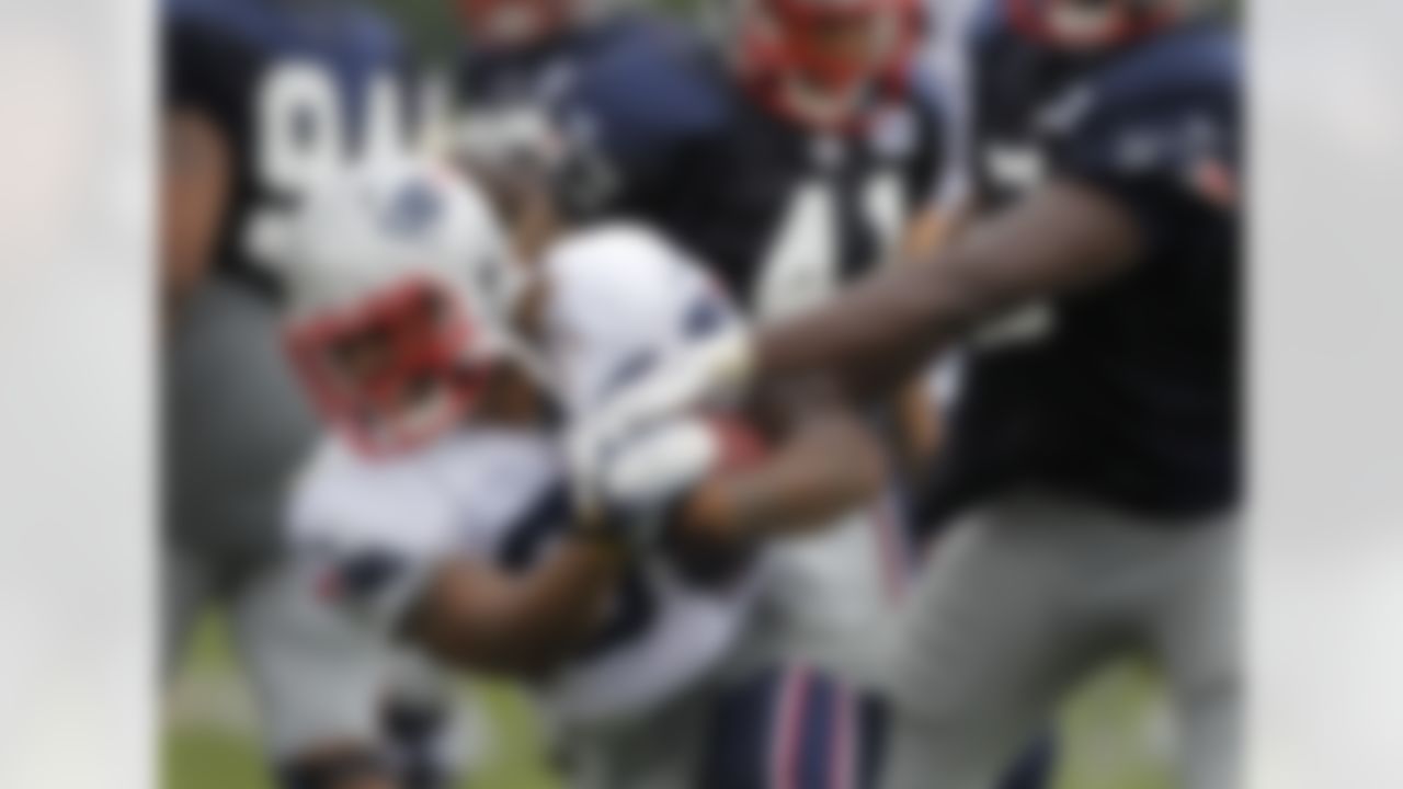 New England Patriots running back Brandon Bolden (38), front left, looks for an opening in the defense as New England Patriots defensive end Chandler Jones (95), hands only at right, tries to stop him during a team NFL football training camp in Foxborough, Mass., Sunday, July 29, 2012. (AP Photo/Steven Senne)