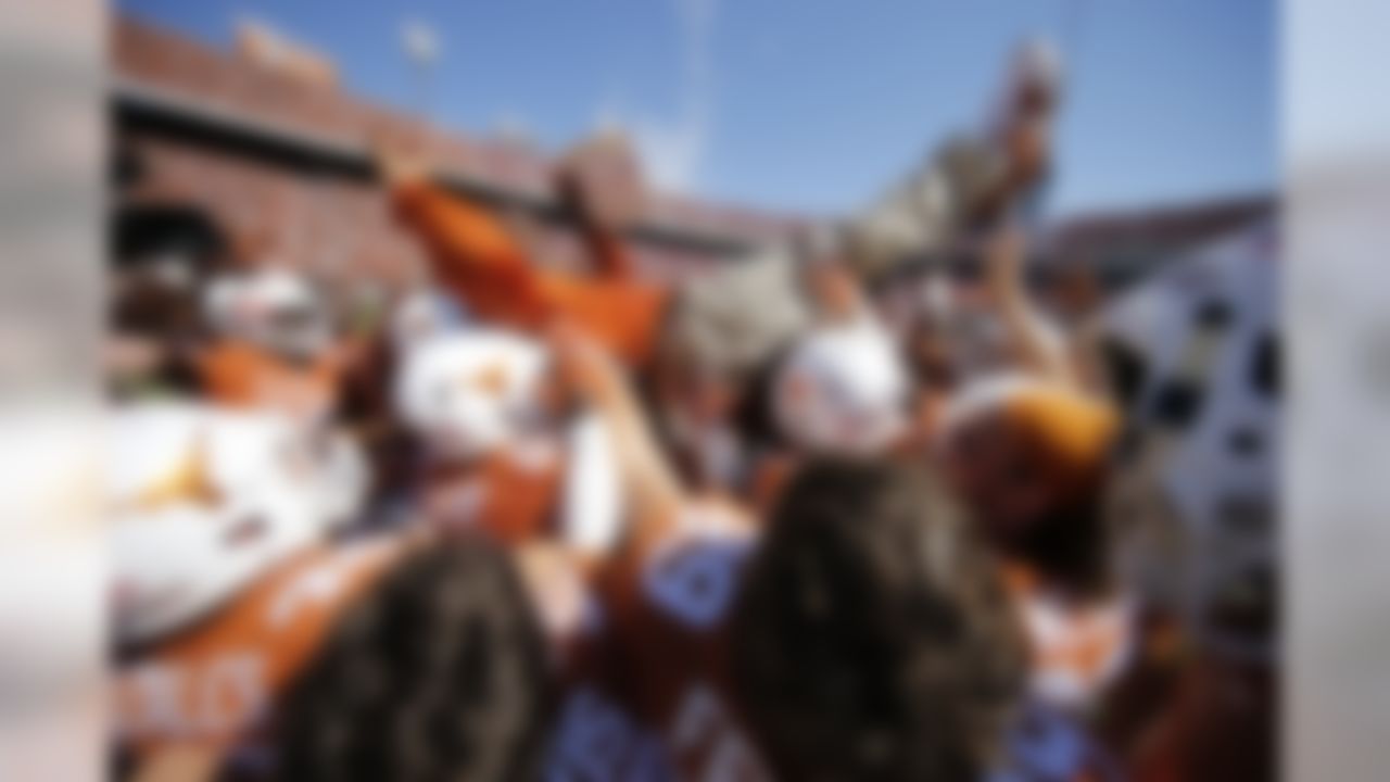 Texas Longhorns players lift Texas Longhorns head coach Charlie Strong in the air during an NCAA Football regular season Red River Rivalry game against the Oklahoma Sooners on Saturday, Oct. 10, 2015 in Dallas. (Ric Tapia/NFL)