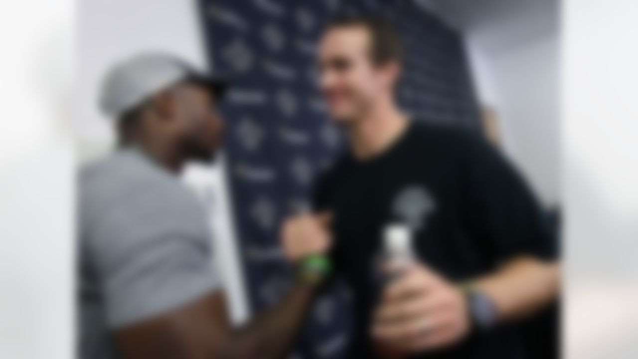 New Orleans Saints quarterback Drew Brees, right, greets safety Roman Harper after players reported for training camp at the NFL football team's facility in Metairie, La., Tuesday, July 24, 2012. (AP Photo/Gerald Herbert)