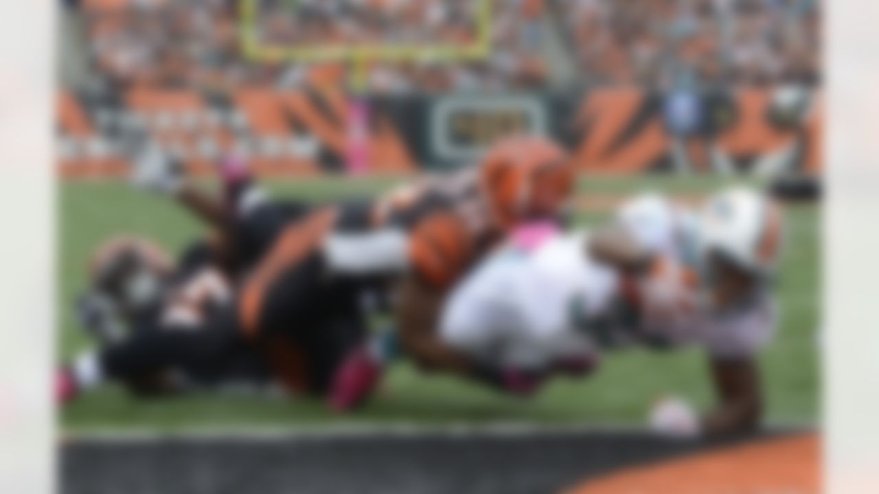 Miami Dolphins running back Daniel Thomas (33) dives past Cincinnati Bengals cornerback Nate Clements (22) for a one-yard touchdown run in the first half of an NFL football game, Sunday, Oct. 7, 2012, in Cincinnati. (AP Photo/Michael Keating)