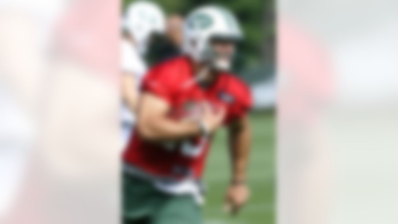 New York Jets quarterback Tim Tebow runs with the ball during practice on opening day of their NFL football training camp Friday, July 27, 2012, in Cortland, N.Y. (AP Photo/Bill Kostroun)