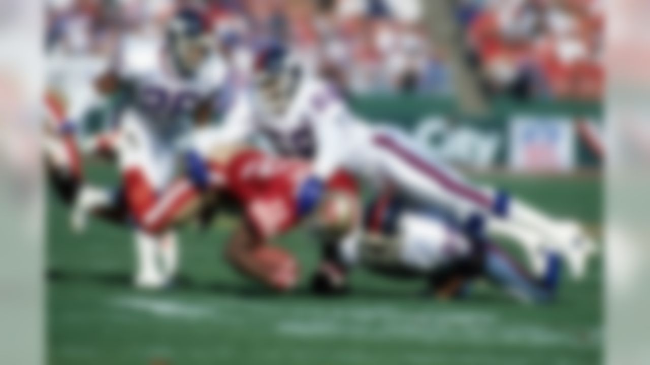 Hall of Fame linebacker Lawrence Taylor (56) of the New York Giants tackles 49ers running back Ricky Watters (32) during the Giants 44-3 loss to the San Francisco 49ers in the 1993 NFC Divisional Playoff Game on January 15, 1994 at Candlestick Park in San Francisco, California. (National Football League)
