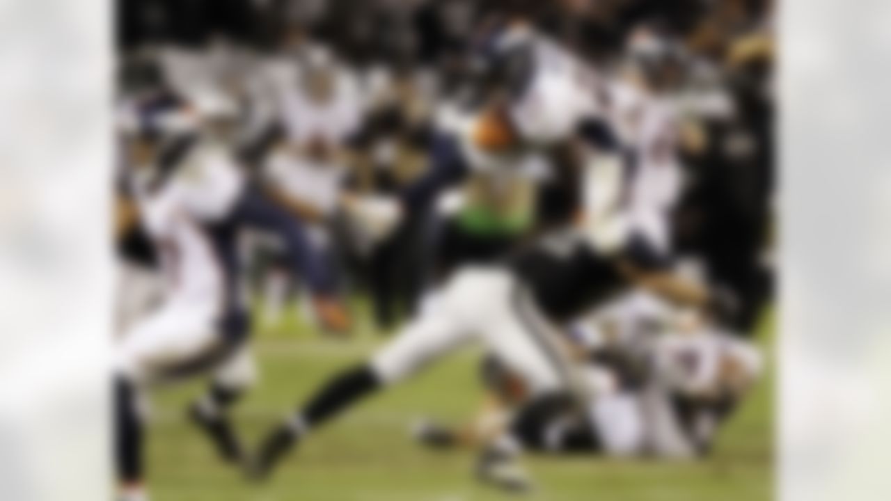 Denver Broncos running back Knowshon Moreno carries the ball and leaps over Oakland Raiders linebacker Philip Wheeler during the fourth quarter of an NFL football game in Oakland, Thursday, Dec. 6, 2012. (AP Photo/Ben Margot)