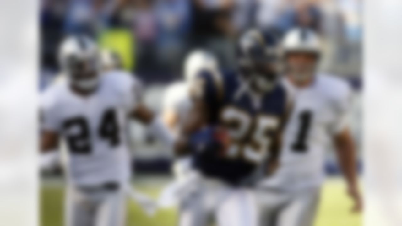 San Diego Chargers' Antonio Cromartie runs the sideline on a 91-yard kickoff return as Oakland Raiders Michael Huff and kicker Sebastian Janikowski gives chase during the second quarter of their football game San Diego, Calif., Sunday, Nov. 26, 2006. The run-back set up a Chargers' touchdown. (AP Photo/Denis Poroy)