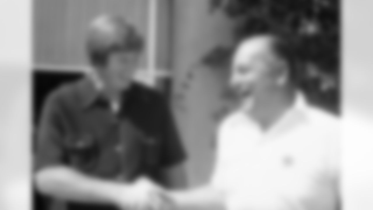 Bob Lilly, left, professional football standout for the Dallas Cowboys, and Tex Schramm, general manager of the Cowboys, share large smiles and a hand shake as Lilly rejoined the training camp Thursday, July 19, 1973 in Thousand Oaks, California. Lilly, who was rumored to be considering announcing his retirement, joined the camp only hours after his arrival from Dallas. (Associated Press)