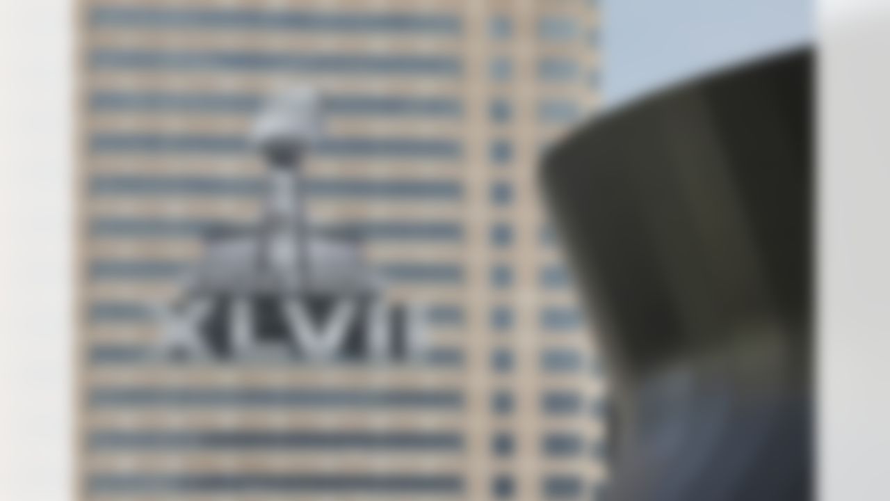 The NFL Super Bowl XLVII NFL football game logo is seen past the Mercedes-Benz Superdome on the face of an office building as preparations take place on Sunday, Jan. 27, 2013, in New Orleans. The Baltimore Ravens and San Francisco 49ers are scheduled to play in Super Bowl XLVII on Sunday, Feb. 3. (AP Photo/Patrick Semansky)