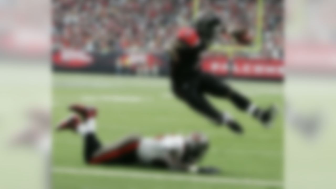 Atlanta Falcons quarterback Michael Vick gets over Tampa Bay Buccaneers linebacker Derrick Brooks (55) for a first quarter touchdown during NFL football play at the Georgia Dome in Atlanta, Sunday, Sept. 17, 2006. (AP Photo/John Amis)