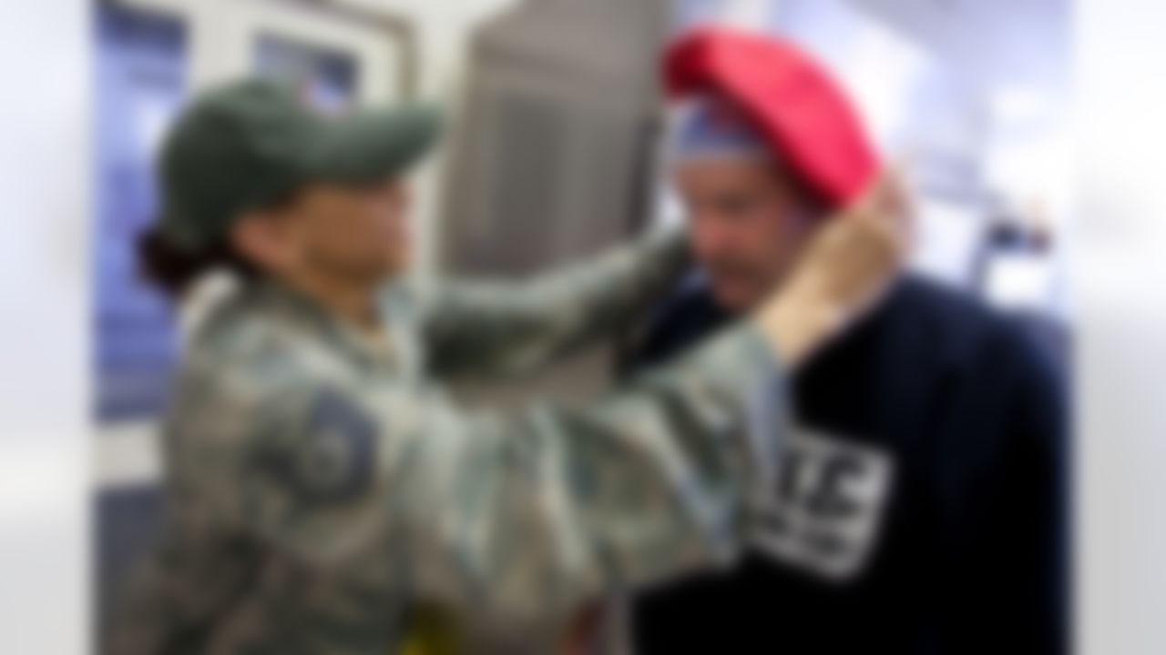 Minnesota Vikings head coach Brad Childress gets some help after trading hats with TSgt Tamala Williams, a cook at a dining facility at Ramstein Air Base in Germany during a USO/Armed Forces Entertainment tour stop on June 30, 2010. This is Childress' first tour and he is joined by three other top NFL coaches who are touring bases in Germany and the Persian Gulf. (Fred Greaves/USO)