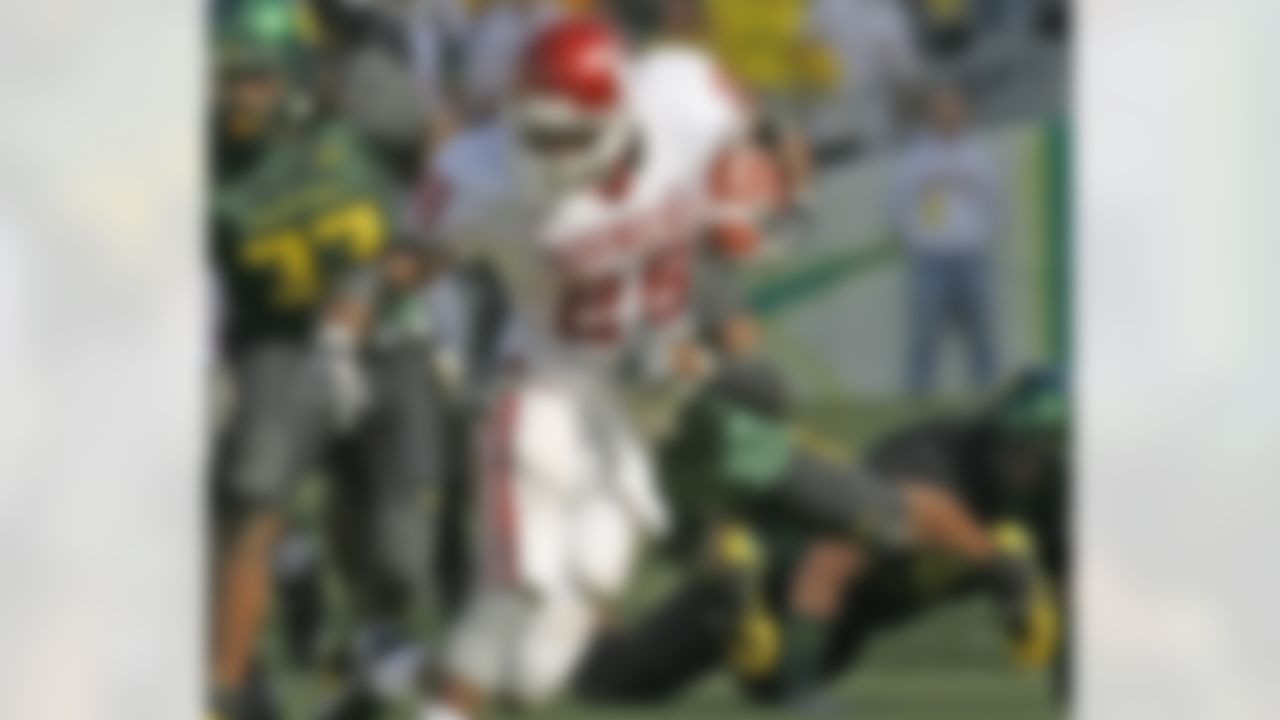 Oregon's Derrick Jones hangs on to Oklahoma's Adrian Peterson (28) as he carries the ball in the fourth quarter of their college football game Saturday, Sept. 16, 2006. Oregon defeated Oklahoma, 34-33. (AP Photo/Rick Bowmer)