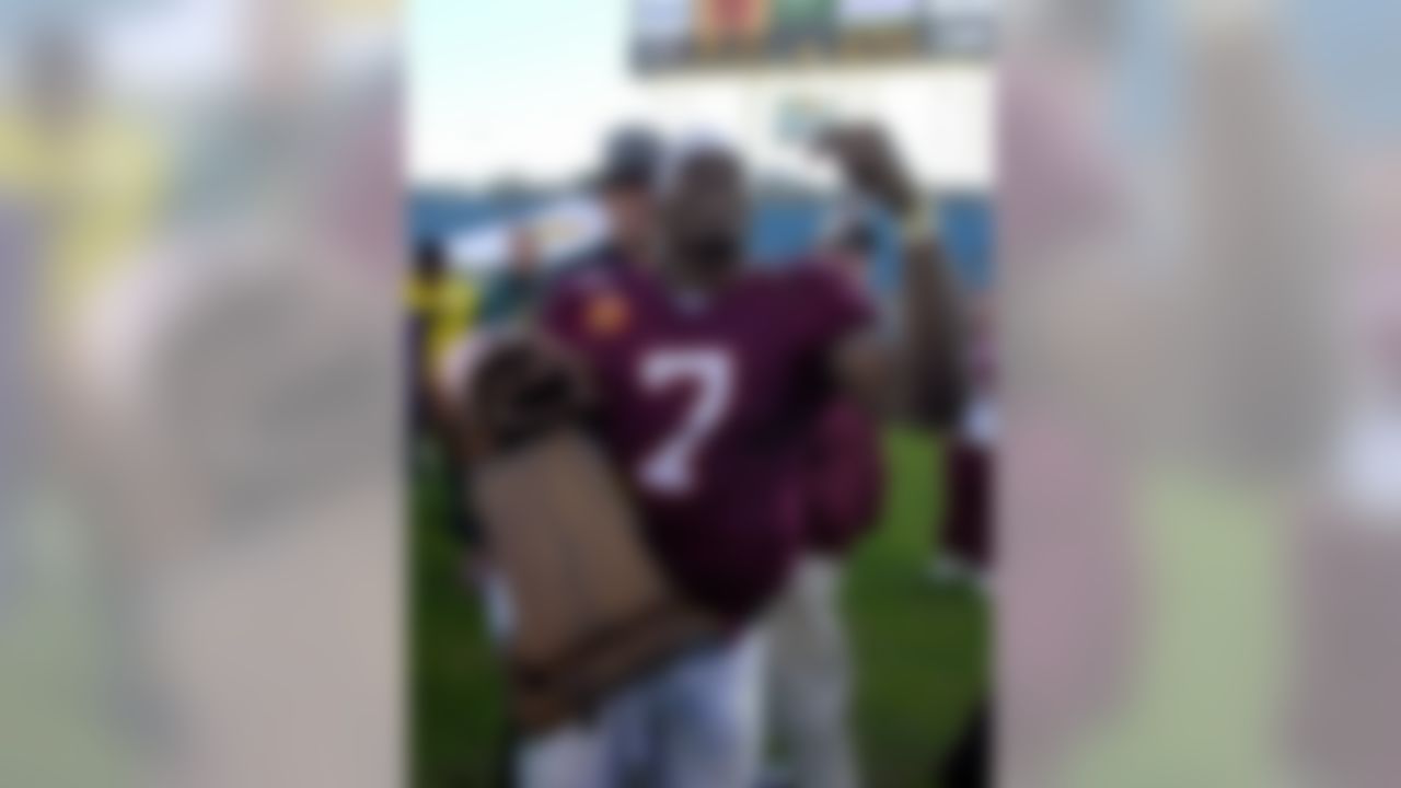 Virginia Tech quarterback Michael Vick holds up the MVP trophy after his team defeated the Clemson Tigers 41-20 to win the Gator Bowl in Jacksonville, Fla., Monday, Jan. 1, 2001. (AP Photo/Mark Foley)