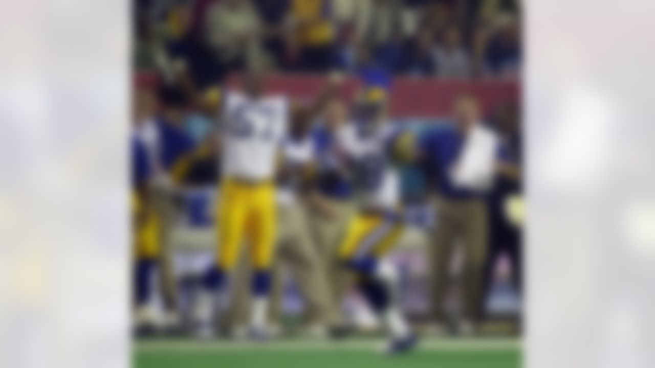St. Louis Rams running back Marshall Faulk (28) catches a pass for a 52-yard gain in the first quarter as teammate Leonard Little (57) cheers him on from the sideline in the first quarter during Super Bowl XXXIV in Atlanta, Sunday Jan.30, 2000. (AP Photo/John Bazemore)