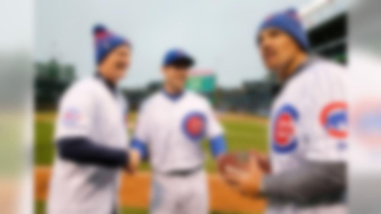 Chicago Cubs outfielder Matt Szczur, center, greets NFL Network's Mike Manock, left, and Kurt Warner prior to an MLB baseball game against the Milwaukee Brewers on Tuesday, April 26, 2016 at Wrigley Field in Chicago. (Alix Kane via AP)