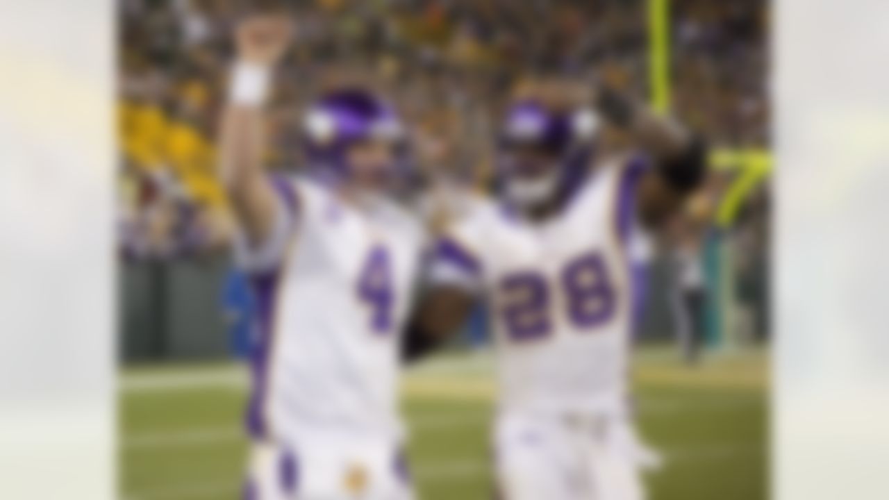 Minnesota Vikings quarterback Brett Favre (4) and running back Adrian Peterson (28) celebrate a touchdown late in the fourth quarter during an NFL football game against the Green Bay Packers at Lambeau Field in Green Bay, Wisconsin on November 1, 2009. The Vikings won 38-26. (AP Photo/David Stluka)